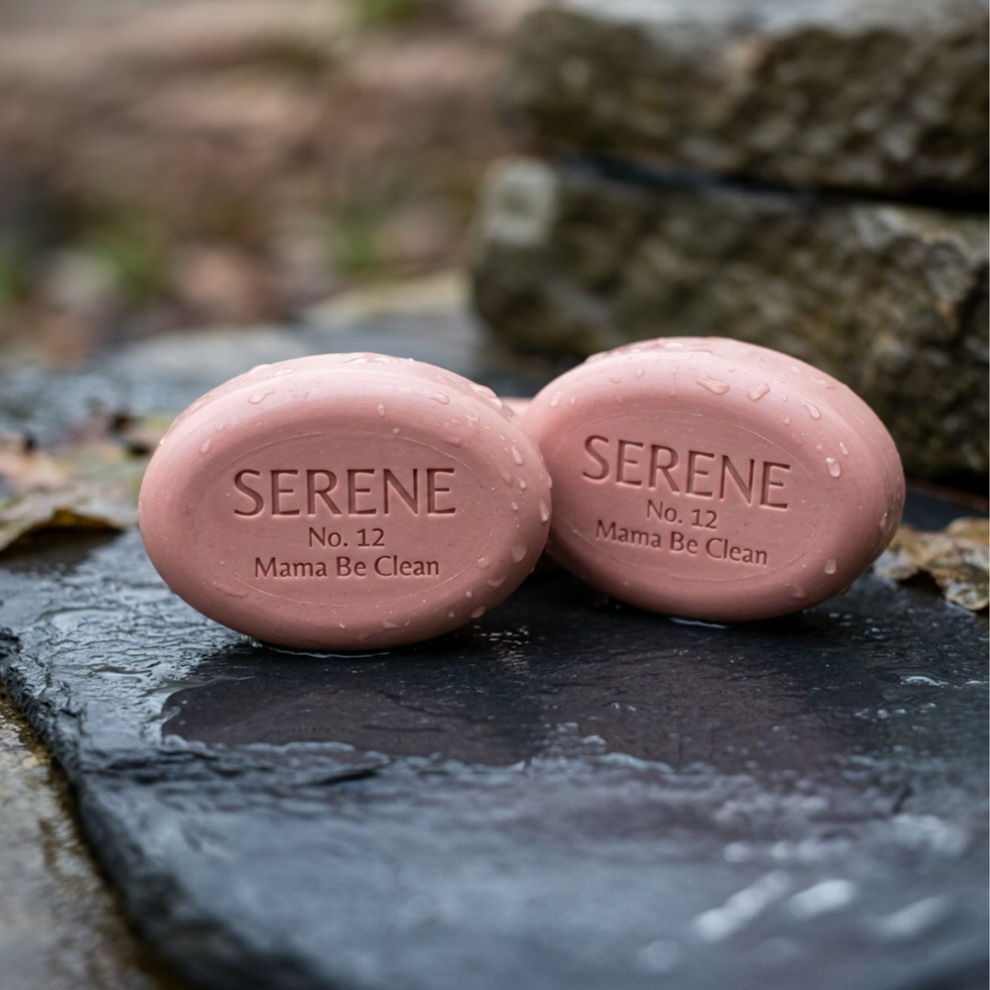 This shows two SERENE ovals, embossed with the No. 09 designation, resting on a dark slate background. The lighting highlights the mineral texture of the Calamine base.