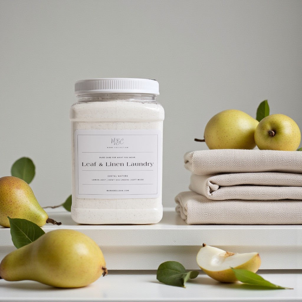 Jar of 'Leaf & Linen Laundry' powder with pears and folded fabric on a light background