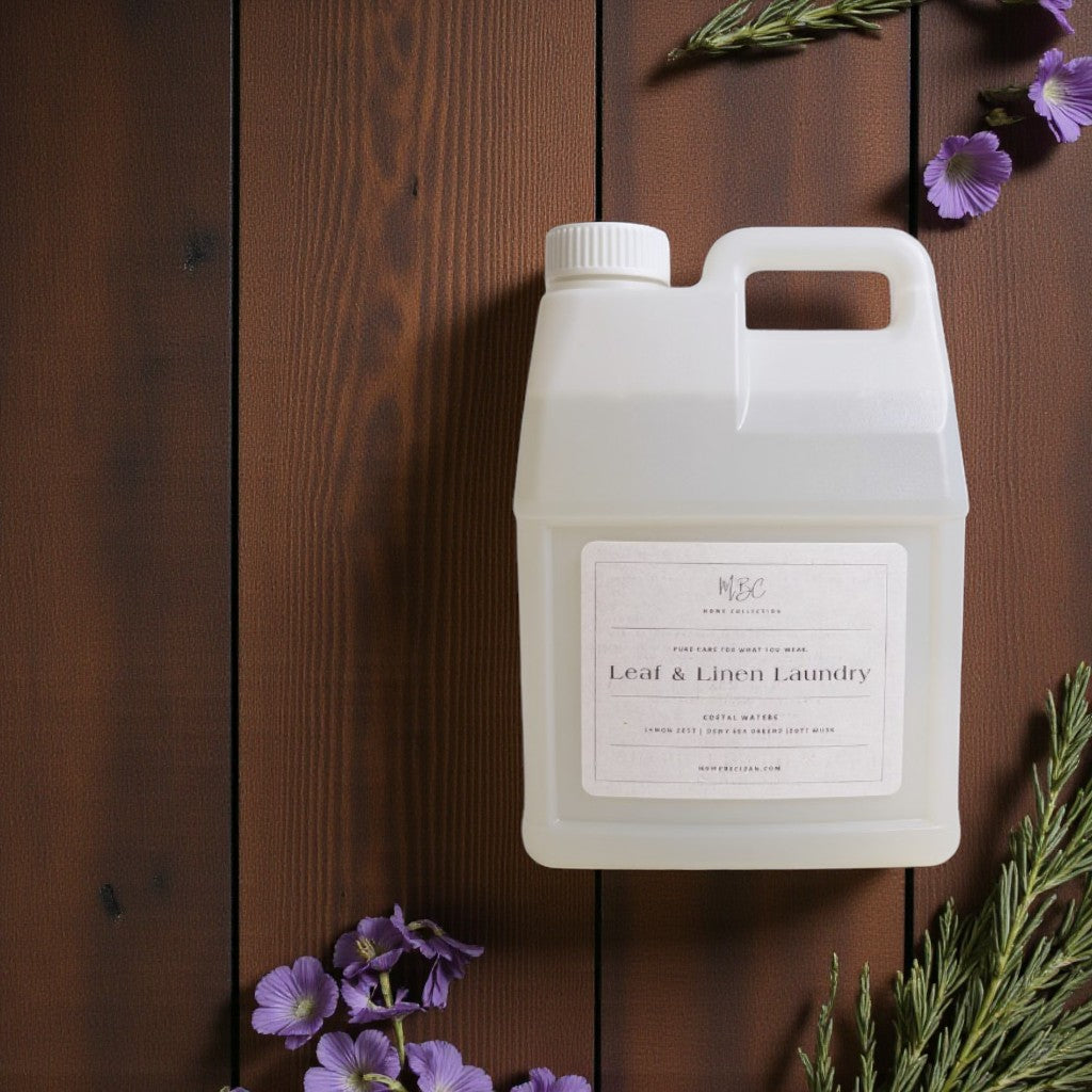 White laundry detergent container on a wooden surface with purple flowers and green leaves.