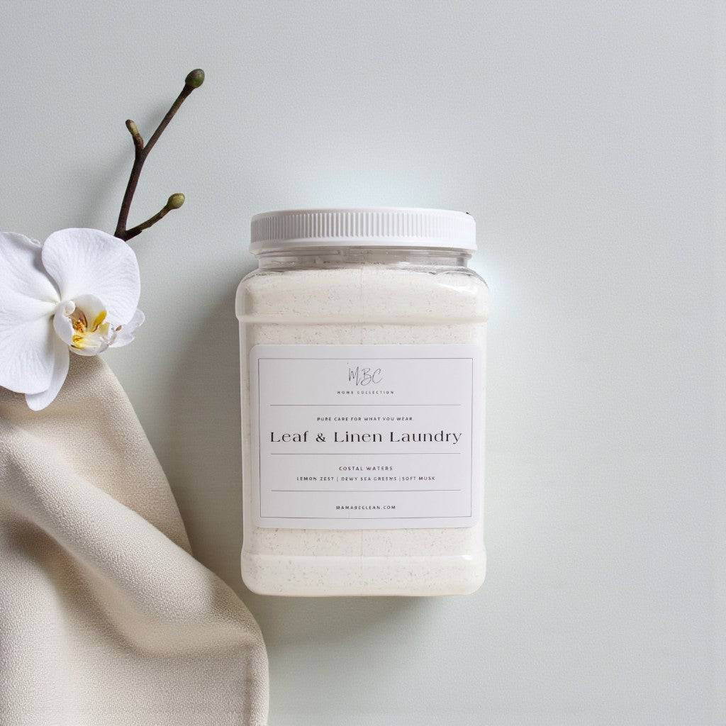 Jar of leaf and linen laundry detergent with a white orchid and branch on a light background